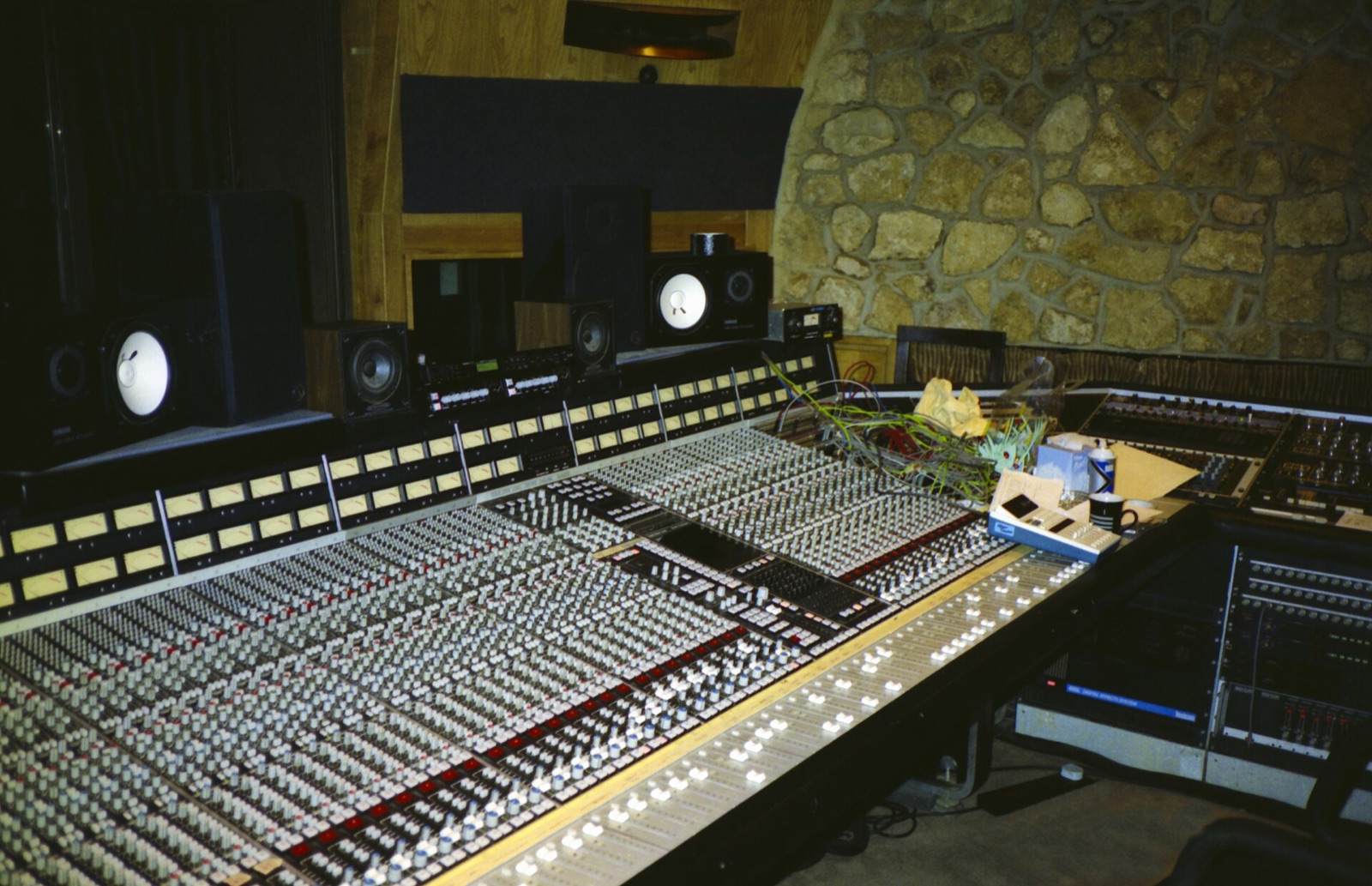 A large mixing desk in a stone-walled control room