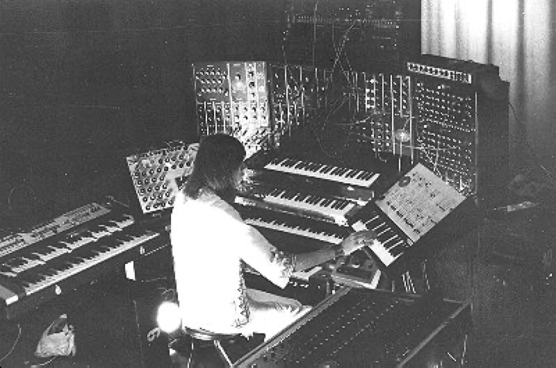 Klaus Schulze sitzt inmitten seiner Synthesizer auf der Bühne